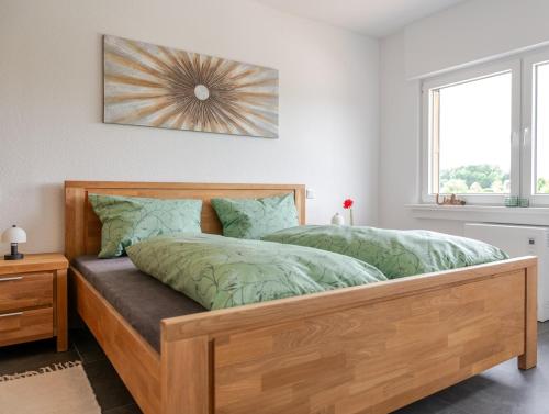 a bedroom with a wooden bed with green comforter at Ferienwohnung Anna in Heimbach