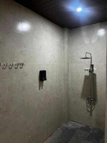 a bathroom with a shower with a phone on the wall at Batan Bingin House in Ubud