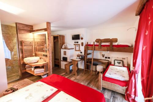 a bedroom with two bunk beds and a desk at Majon de la nona in Pozza di Fassa