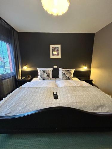 a bedroom with a large bed with a cell phone on it at Hotel Alter Posthof in Spay