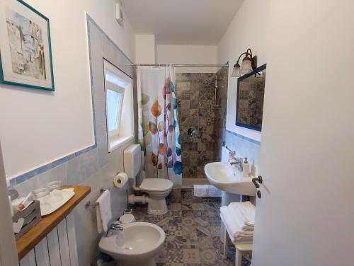 a bathroom with two sinks and a toilet and a shower at Guest House La Carolina in Tigliole