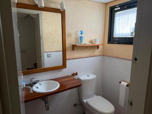 a bathroom with a toilet and a sink and a mirror at Les Oliveres Beach in Perelló