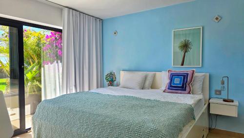 a blue bedroom with a bed with a pillow on it at Apartment Monte Del Moro in San Agustin
