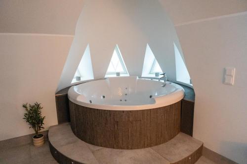 a round bath tub in a room with a window at Glorious penthouse with private sauna and jacuzzi in Helsinki
