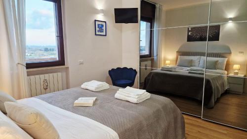 a hotel room with two beds and a mirror at EOS Suite Apartment - a due passi da Piazza Pisanelli e Ospedale Panico in Tricase
