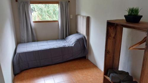 a couch in the corner of a room with a window at Vientos del Lago - Tu refugio en la Patagonia in Los Antiguos