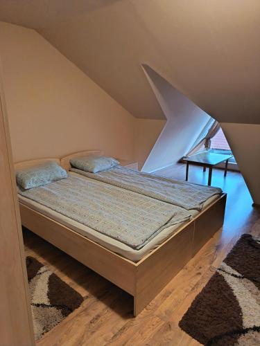 a bed in a room with an attic at Timi Kulcsosház in Lăzarea