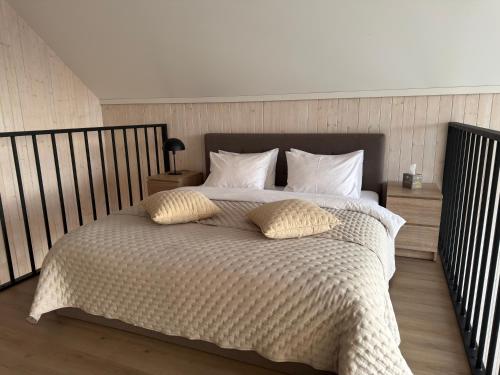 a bedroom with a large bed with two pillows at WakeMālpils brīvdienu mājas in Mālpils