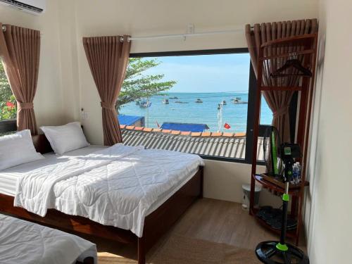 a bedroom with a bed and a view of the ocean at Sola Hòn Sơn in Lai Sơn