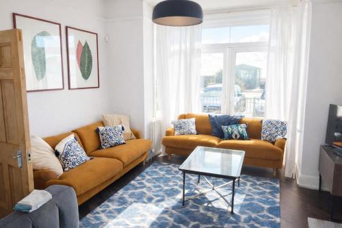 a living room with two couches and a table at Beautiful 4 Bed Beach House in Pevensey