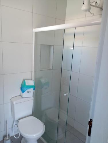 a bathroom with a toilet and a glass shower at imovel 2 e 3 in Guaratuba