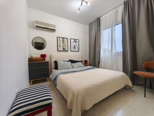 ein weißes Schlafzimmer mit einem Bett und einem Fenster in der Unterkunft Faros in Paphos City