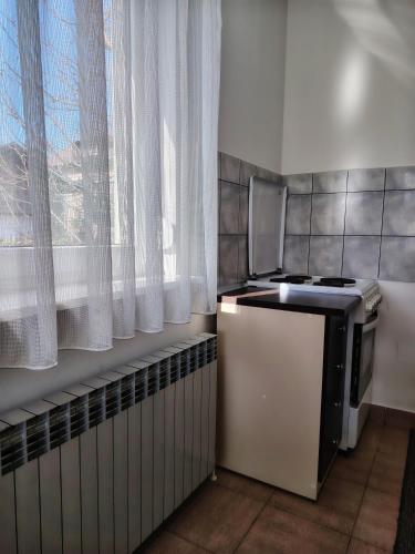 a kitchen with a small refrigerator and a window at Apartment Marija in Slavonski Brod
