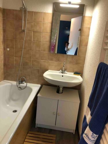 a bathroom with a sink and a tub and a mirror at Abondance appartement 4 pers in Abondance