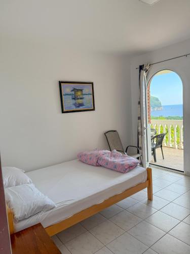 a bedroom with a bed and a view of a patio at Vila Pogled in Petrovac na Moru