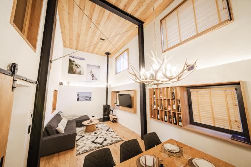 a living room with a large window and a table at Chalet Charm - Private Mountain Retreat with Sauna, Jacuzzi & Kids Playroom in Bansko