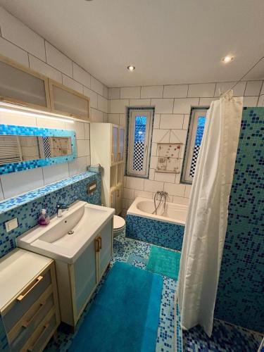 a blue and white bathroom with a sink and a tub at Zum Langschläfer in Fredersdorf