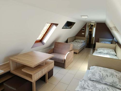 a room with two beds and a couch and a table at Róma Apartmanház in Bogács