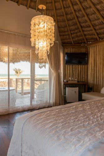 a bedroom with a large bed and a chandelier at Positano Village in Canoa Quebrada