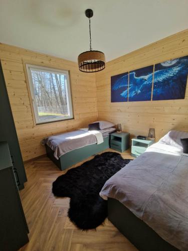a bedroom with two beds and a large rug at Azyl na Polesiu domki przy Poleskim Parku Narodowym in Załucze Nowe