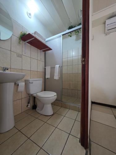 a bathroom with a toilet and a shower and a sink at Fortuna garden hotel in Fortuna