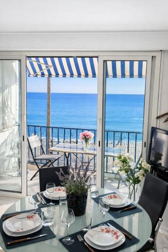 a dining table with a view of the ocean at Le Reflet d'Azur - les pieds dans l'eau in Antibes