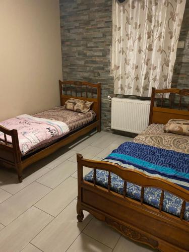 two twin beds in a room with a window at Home stay Spacious room in Massy