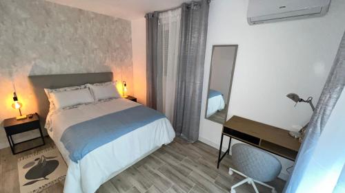 a bedroom with a bed and a desk and a mirror at Villamadrid Home in Madrid