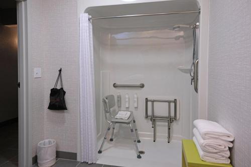 a bathroom with a chair and a shower at Hampton Inn Lima in Lima