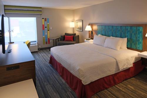 a hotel room with a bed and a chair at Hampton Inn Lima in Lima