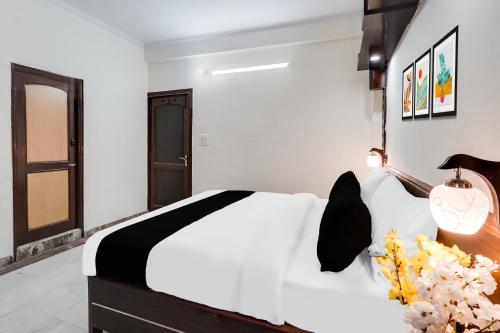 a bedroom with a white bed with flowers on it at HOTEL O 4 SQUARE A LUXURY ROOMS NEAR RDC MAIN MARKET in Ghaziabad