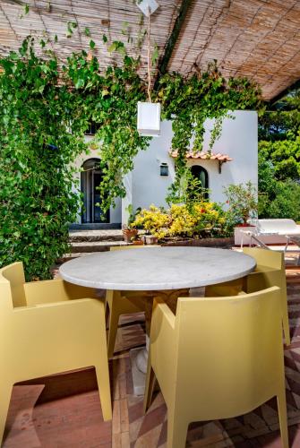 a table and chairs in a patio with plants at Villa Lyla in Capri