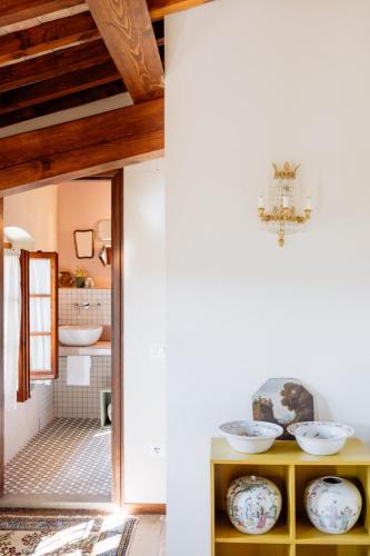 a bathroom with a yellow cabinet with bowls on it at I Casciani in Montespertoli