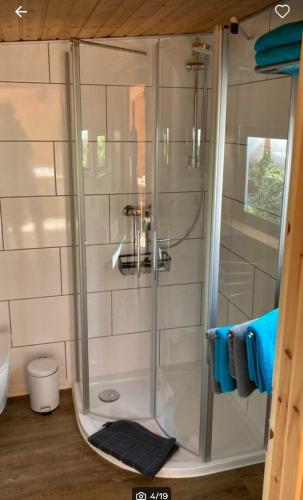 a shower with a glass door in a bathroom at Glamping im Tiny House - nahe Dresden in Freital