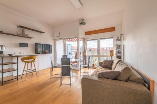 a living room with a couch and a table at Stylish Loft Apartment with Designer Bathroom & Balcony in Berlin