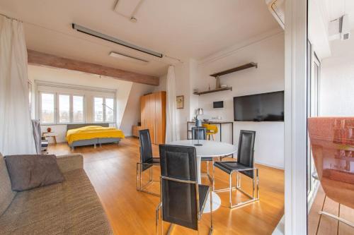 a living room with a table and chairs and a bed at Stylish Loft Apartment with Designer Bathroom & Balcony in Berlin
