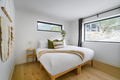 a bedroom with a bed and a window at Spacious 2BR Retreat, Scenic Views, Modern & New in Whistler