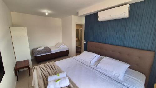 a bedroom with a large bed with a blue wall at Apartamento 2 quartos Blumenau a 10 minutos da Vila Germânica in Blumenau