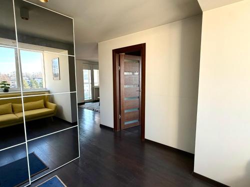 a living room with a mirror and a yellow couch at Birštonas Relax Apartment in Birštonas