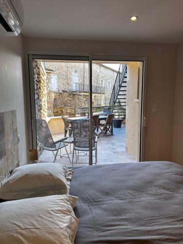 a bedroom with a bed and a view of a patio at La Terrette in Vagnas
