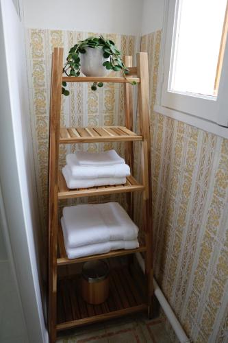 a wooden towel shelf with towels in a bathroom at Maison TORTONI in Bastia