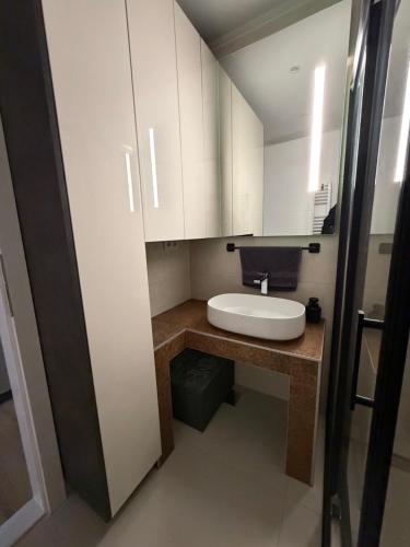 a small bathroom with a white sink and cabinets at Bella Mela 2 in Tuzla