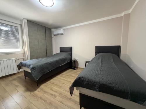 a bedroom with two beds and a window at Bella Mela 2 in Tuzla