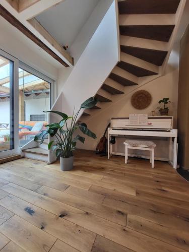 a living room with a piano and a staircase at Kleine Oase in Ettenheim