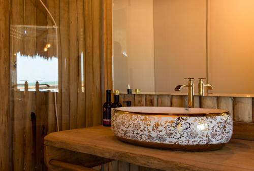 a bathroom with a bowl sink on a wooden counter at Positano Village in Canoa Quebrada