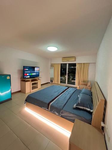 a bedroom with a large bed and a flat screen tv at Bts studio rooms in Bangna