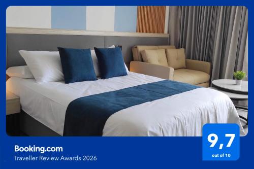 a hotel room with a bed and a chair at ApartaSuite 932 en Porto Horizonte SANTA MARTA in Santa Marta