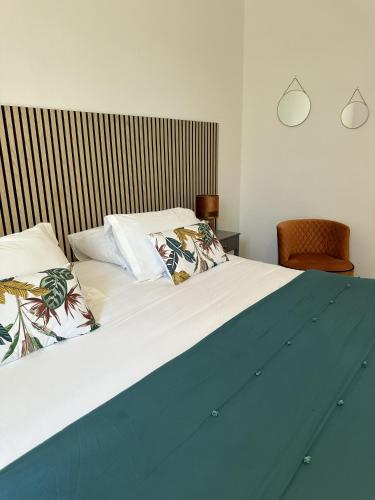 a bed with two pillows on top of it at La Bastide de Vallon in Vallon-Pont-dʼArc