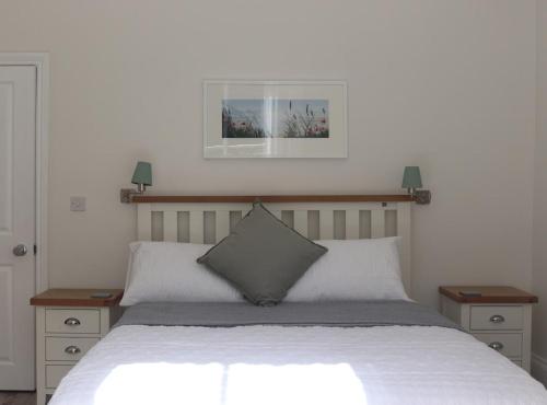 a bedroom with a bed with two night stands and two lamps at Stunning Seafront Apartment in Aberystwyth