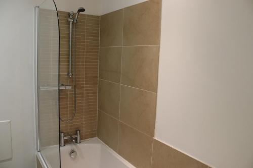 a bathroom with a shower and a bath tub at Stunning Seafront Apartment in Aberystwyth